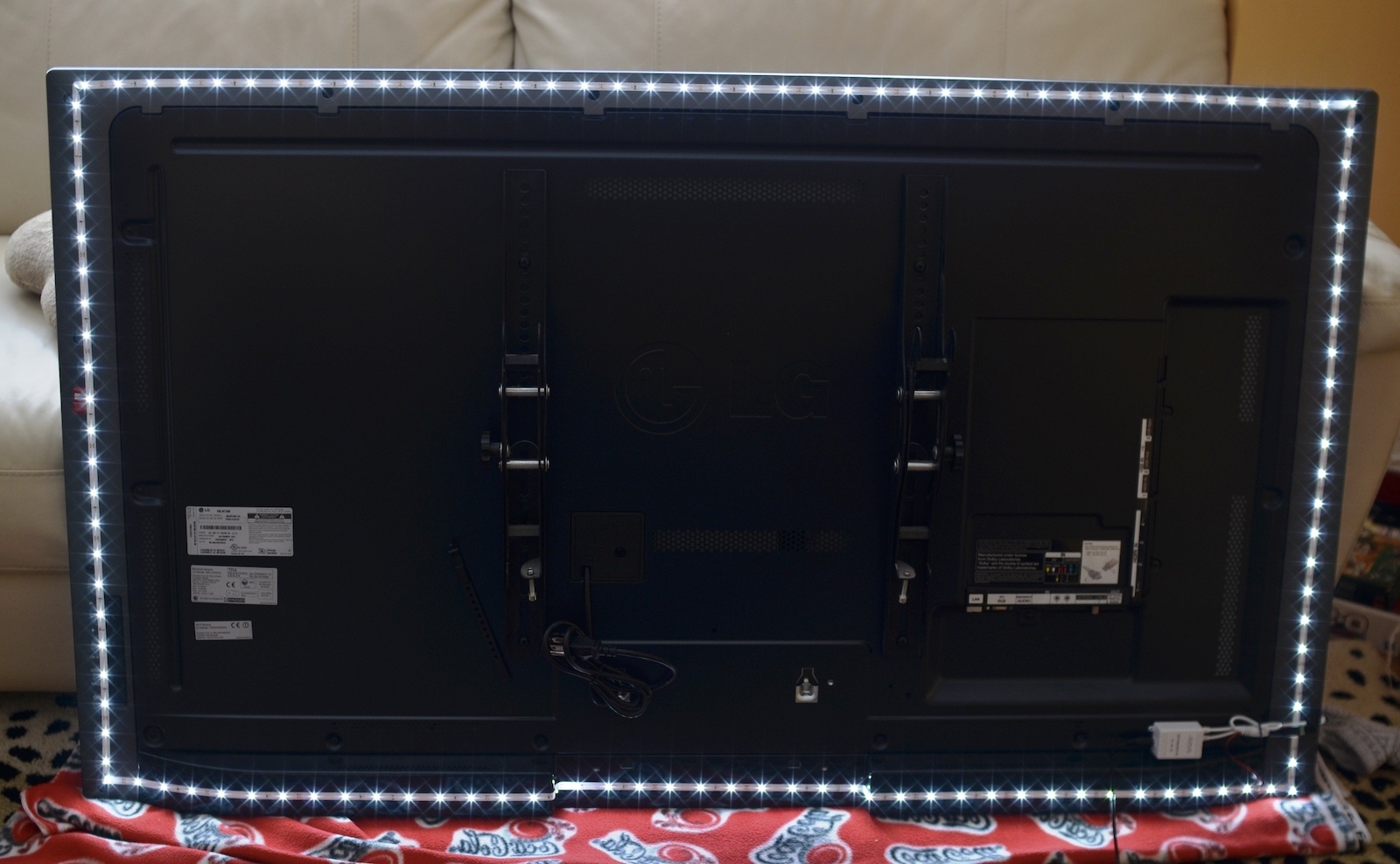 A DIY LED light strip bias lighting setup behind a wall-mounted TV