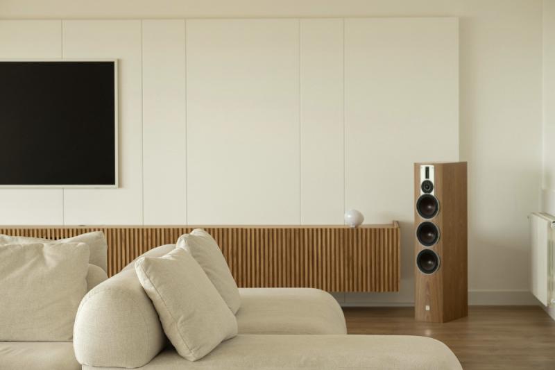 An elegant, minimalist lounge room showing a TV and floor standing speakers
