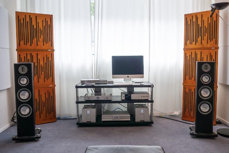 A hi-fi setup with acoustic treatment panels and curtains on the back wall